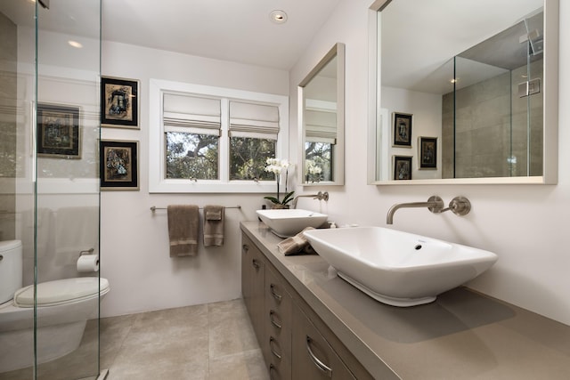 bathroom with vanity, toilet, and a shower with shower door