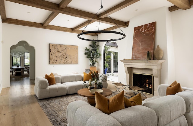 living room featuring hardwood / wood-style floors, beam ceiling, and a premium fireplace