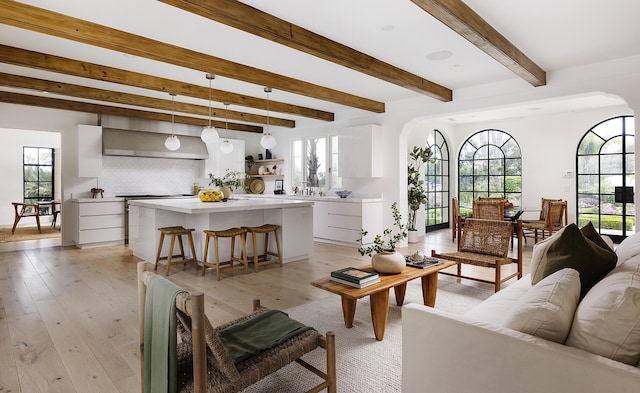 living room with beam ceiling and light hardwood / wood-style flooring