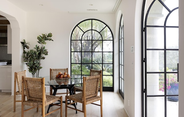 dining area featuring crown molding and light wood-type flooring