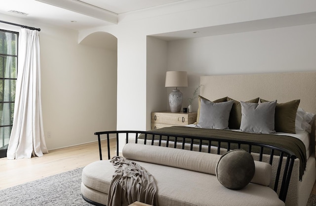 bedroom featuring beamed ceiling and light hardwood / wood-style flooring