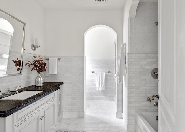 bathroom with tile patterned flooring, vanity, and tile walls