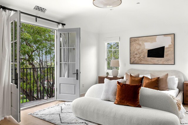 bedroom featuring access to exterior and light wood-type flooring