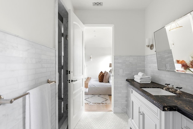 bathroom featuring vanity, tile patterned floors, and tile walls