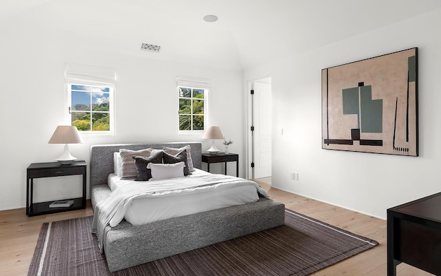 bedroom featuring light hardwood / wood-style floors and lofted ceiling