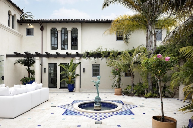 back of house featuring outdoor lounge area and a patio