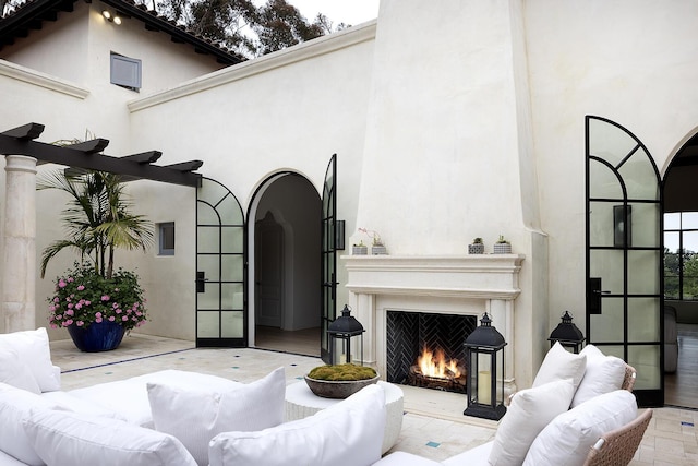 living room featuring a towering ceiling and exterior fireplace