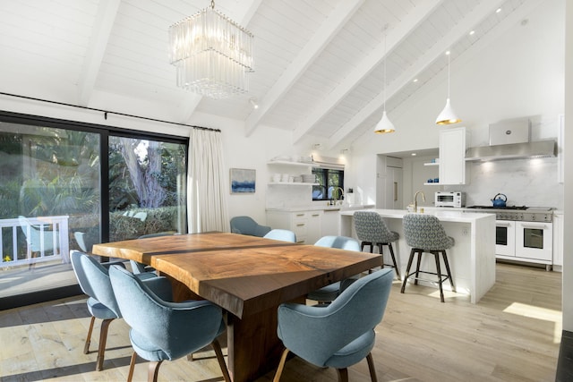 dining area with a notable chandelier, beam ceiling, high vaulted ceiling, and light wood-type flooring