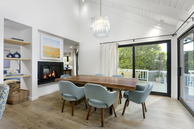 dining area with beamed ceiling, high vaulted ceiling, light hardwood / wood-style flooring, and a notable chandelier