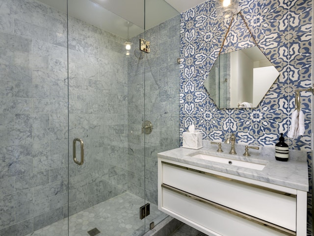 bathroom featuring vanity and a shower with door