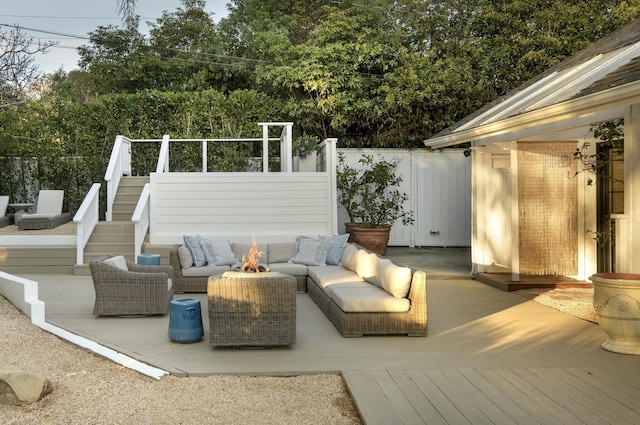 view of patio / terrace with a deck and an outdoor living space with a fire pit