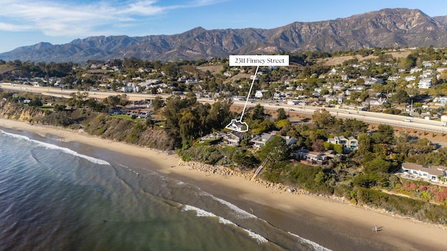 drone / aerial view with a water and mountain view and a beach view