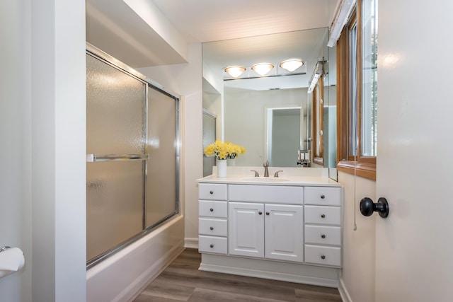 bathroom featuring bath / shower combo with glass door, wood-type flooring, and vanity