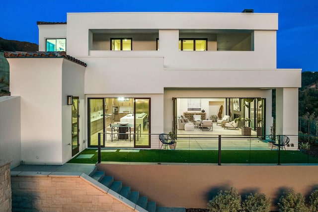 rear view of property featuring a patio area and stucco siding