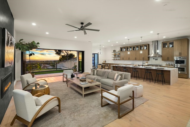 living room featuring light wood-type flooring, a fireplace, and recessed lighting