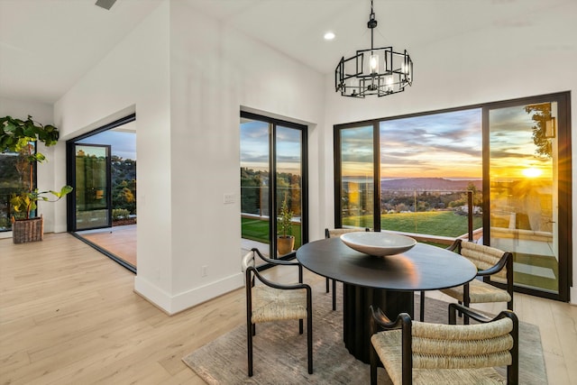 dining room featuring light wood-style floors, recessed lighting, baseboards, and an inviting chandelier