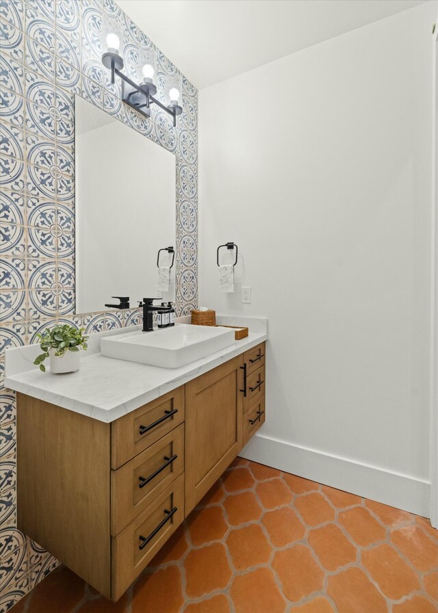 bathroom with an inviting chandelier, baseboards, and vanity