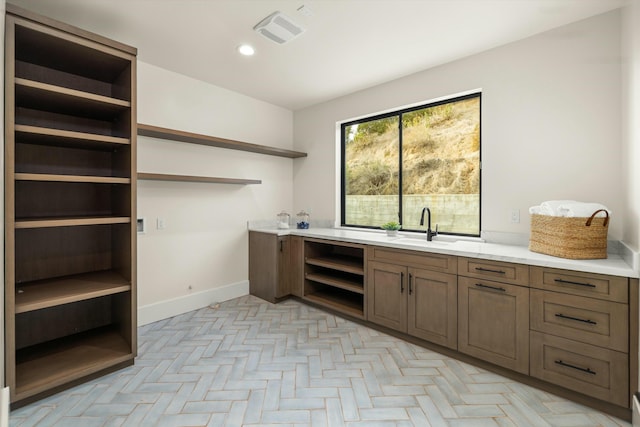 interior space with baseboards, visible vents, a sink, and recessed lighting