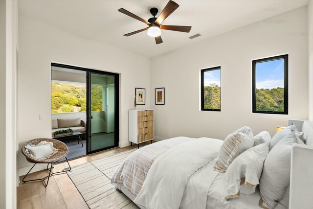 bedroom featuring light wood finished floors, visible vents, baseboards, a ceiling fan, and access to outside