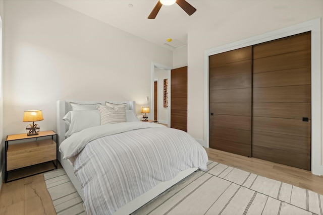 bedroom with a ceiling fan, light wood-type flooring, and a closet