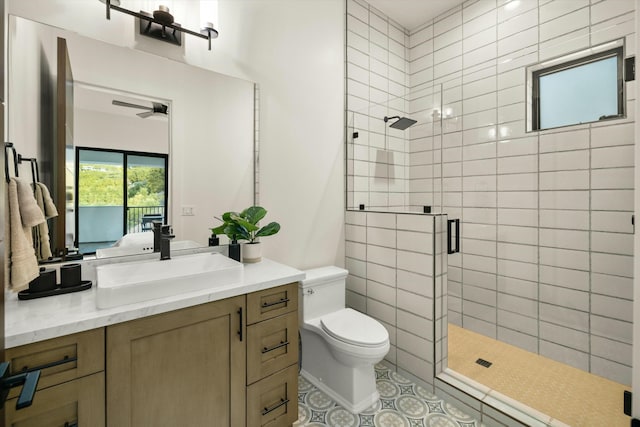 ensuite bathroom with toilet, a ceiling fan, a shower stall, ensuite bath, and vanity