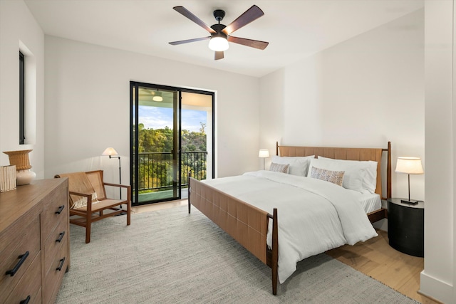 bedroom featuring access to exterior, light wood-style flooring, and a ceiling fan