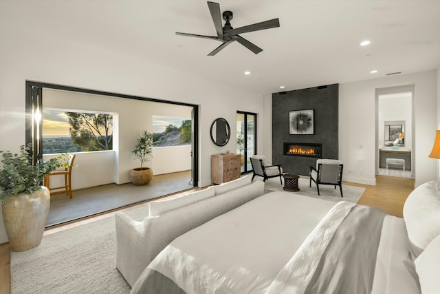 bedroom featuring light wood finished floors, a fireplace, a ceiling fan, and recessed lighting