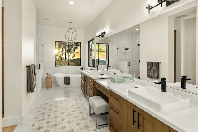 bathroom featuring a notable chandelier, double vanity, a stall shower, a sink, and a freestanding tub