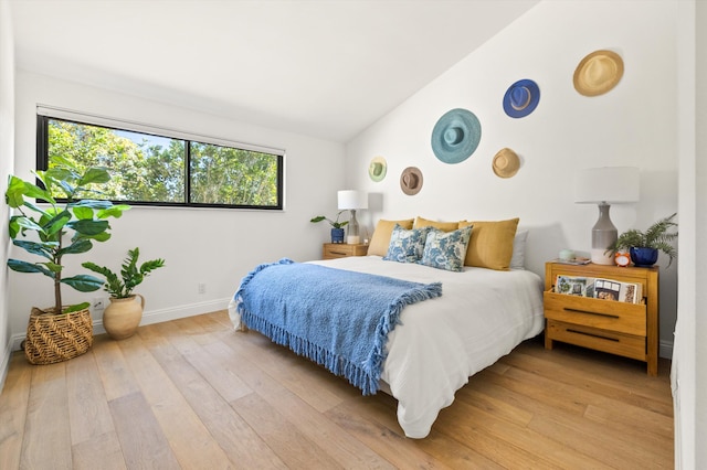 bedroom with lofted ceiling and light hardwood / wood-style flooring