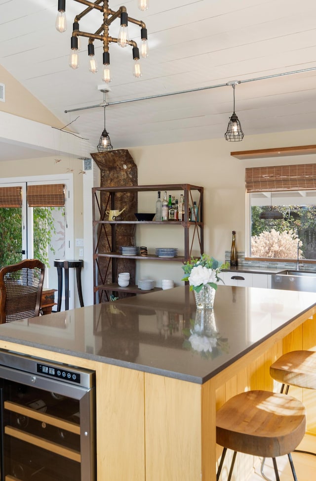 kitchen with sink, a healthy amount of sunlight, lofted ceiling, and wine cooler