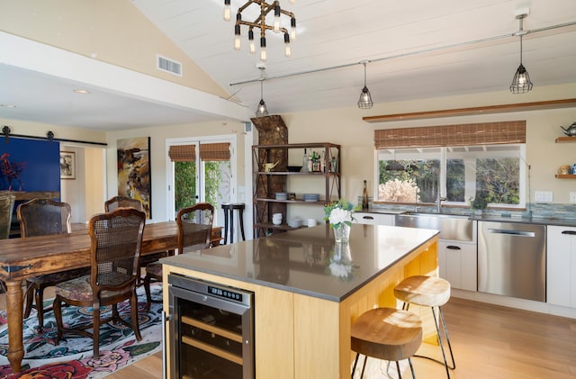 kitchen featuring a barn door, wine cooler, a kitchen island, stainless steel dishwasher, and sink