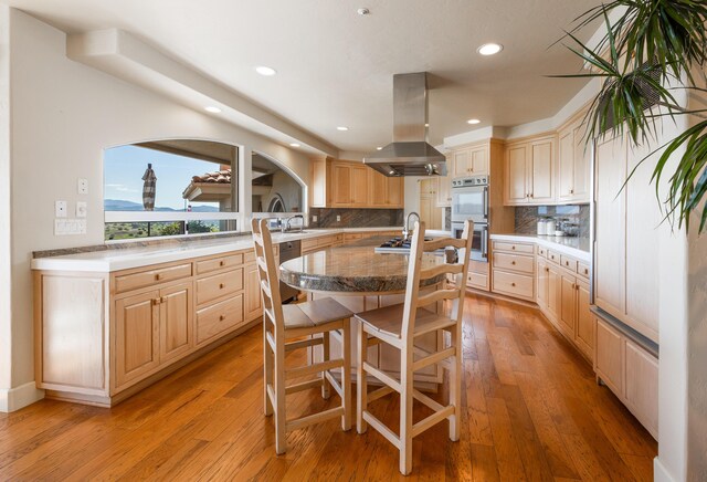 2408 Latigo Dr, Solvang, CA 93463 - kitchen featuring decorative backsplash, island range hood, white double oven, and light brown cabinetry