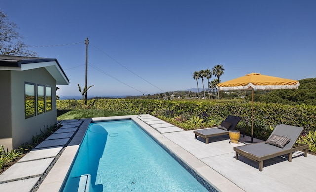 view of swimming pool with a fenced in pool, a patio area, and a mountain view