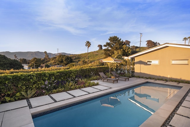 outdoor pool featuring a patio area and a mountain view