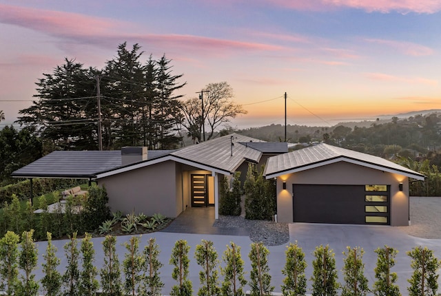 view of front of property featuring stucco siding, driveway, and a garage