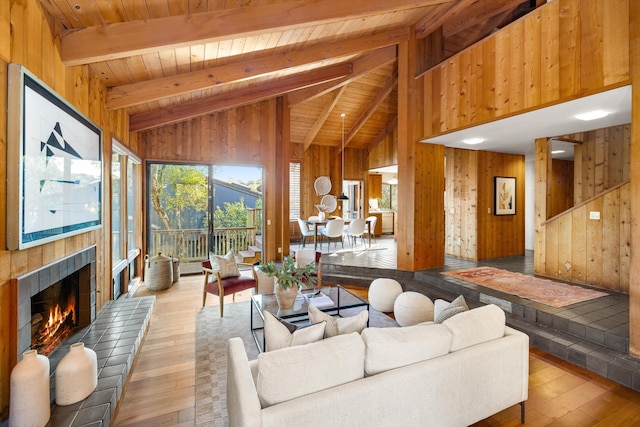 living room with beam ceiling, wooden walls, hardwood / wood-style floors, and wooden ceiling