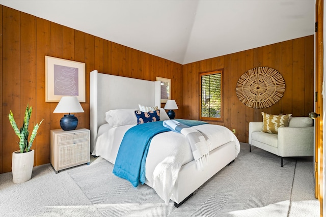 bedroom with wood walls, light carpet, and vaulted ceiling