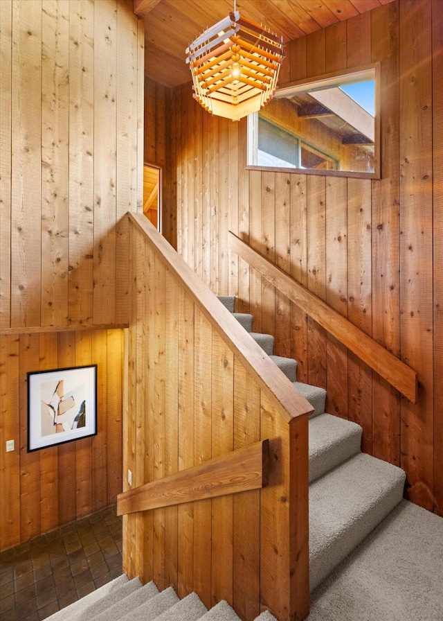 stairway featuring wooden walls