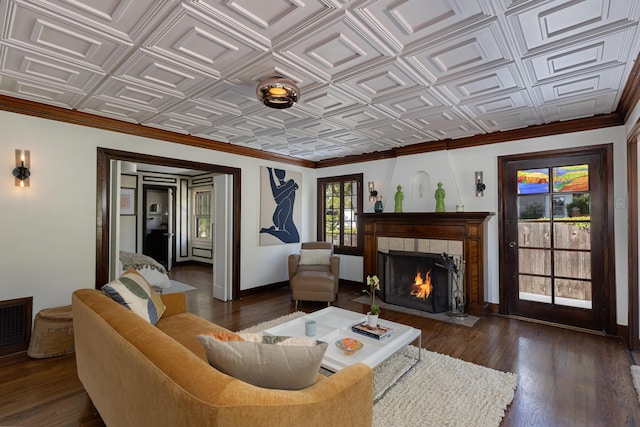 2335 State St, Santa Barbara, CA 93105 - living area featuring dark wood-style flooring, baseboards, a tiled fireplace, an ornate ceiling, and crown molding