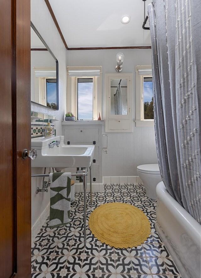 bathroom with crown molding, shower / bath combo, tile patterned floors, and toilet