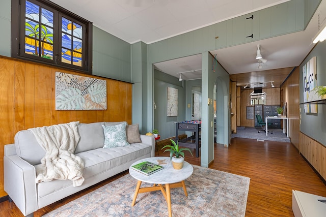 living room with ceiling fan, dark wood-type flooring, and wooden walls