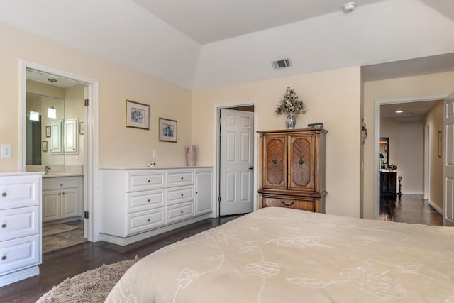 bedroom with sink, dark wood-type flooring, and connected bathroom