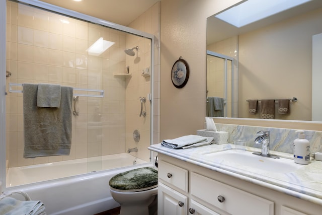 full bathroom featuring vanity, toilet, enclosed tub / shower combo, and a skylight