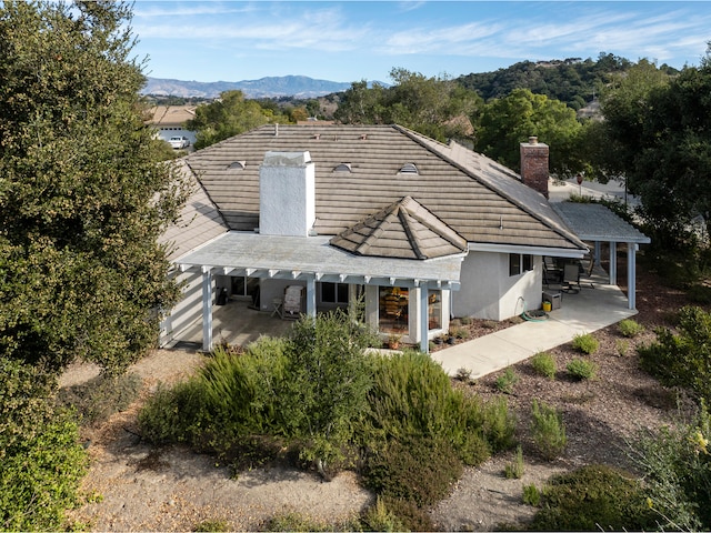 back of house featuring a mountain view and a patio