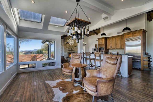 interior space with a mountain view, high vaulted ceiling, a stone fireplace, beam ceiling, and dark hardwood / wood-style flooring