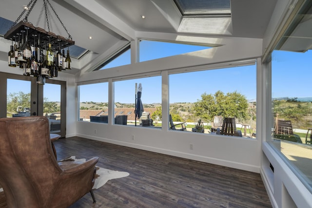 sunroom featuring vaulted ceiling with beams and a notable chandelier