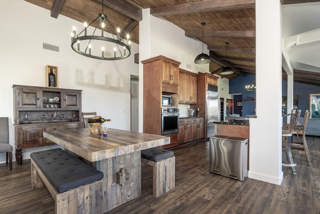 kitchen with pendant lighting, beam ceiling, stainless steel appliances, and high vaulted ceiling