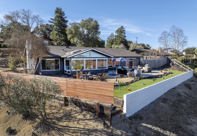 back of property featuring outdoor lounge area, a patio area, and a lawn