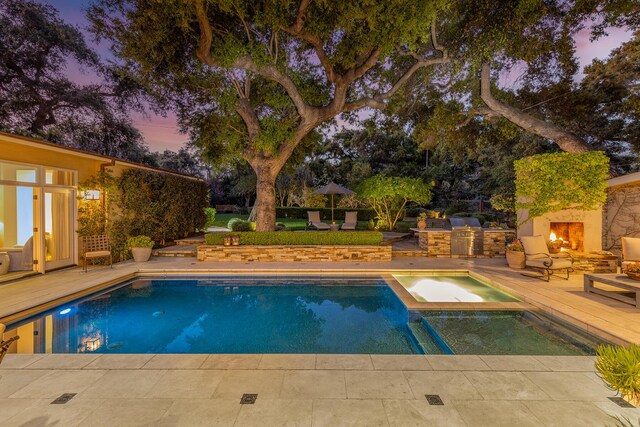 708 Cuyama Rd, Ojai, CA 93023 - pool at dusk featuring an in ground hot tub, a patio, and an outdoor stone fireplace