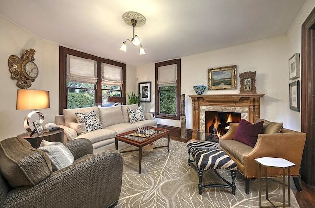 living room with wood-type flooring, a high end fireplace, and a chandelier